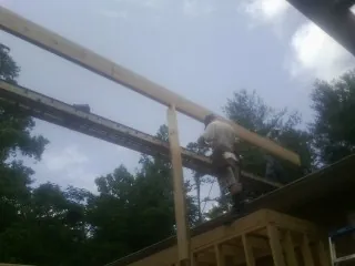 Carpenter setting a ridge beam over a new addition frame — Ice Dam Removal by Roofing Brothers in King Of Prussia