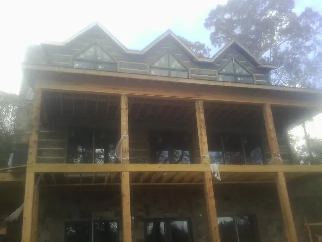 Dormers and porch framing on a large log home under construction — Roof Coating work by our crew in King Of Prussia