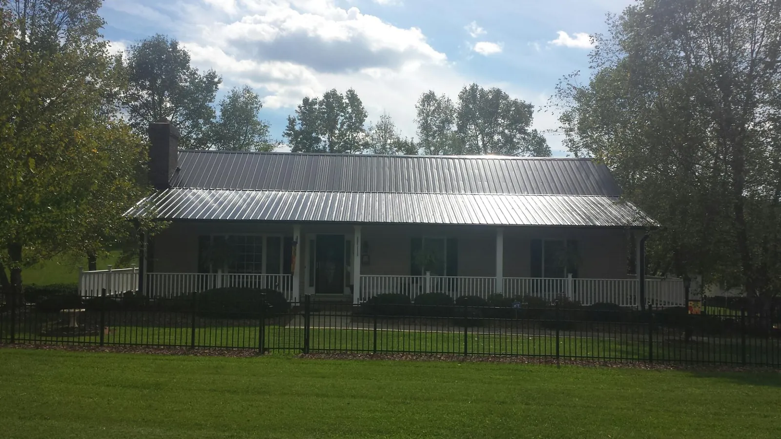Gray metal roof on a brick ranch with a full width front porch — Gutter Guard Installation work by our crew in King Of Prussia