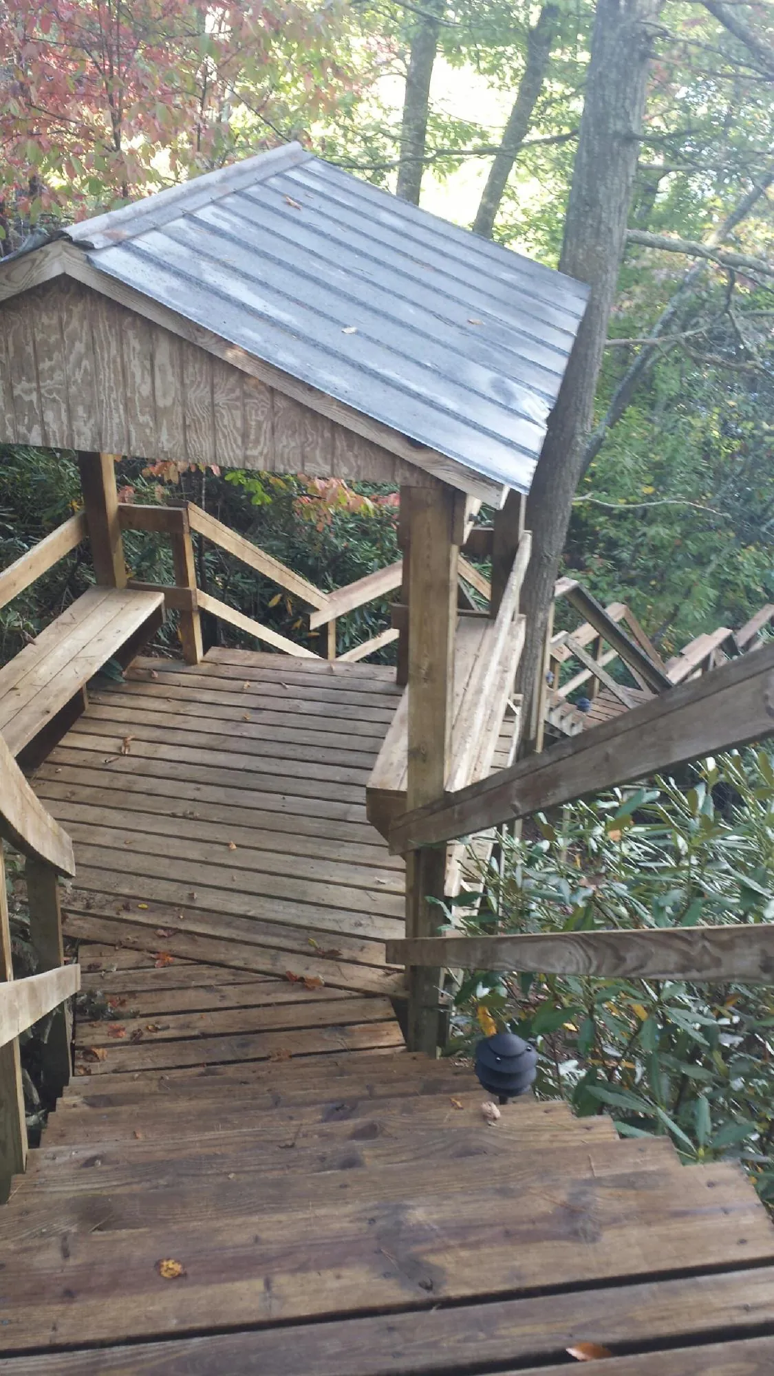 Metal roofed shelter over wooden steps on a wooded walkway in King Of Prussia