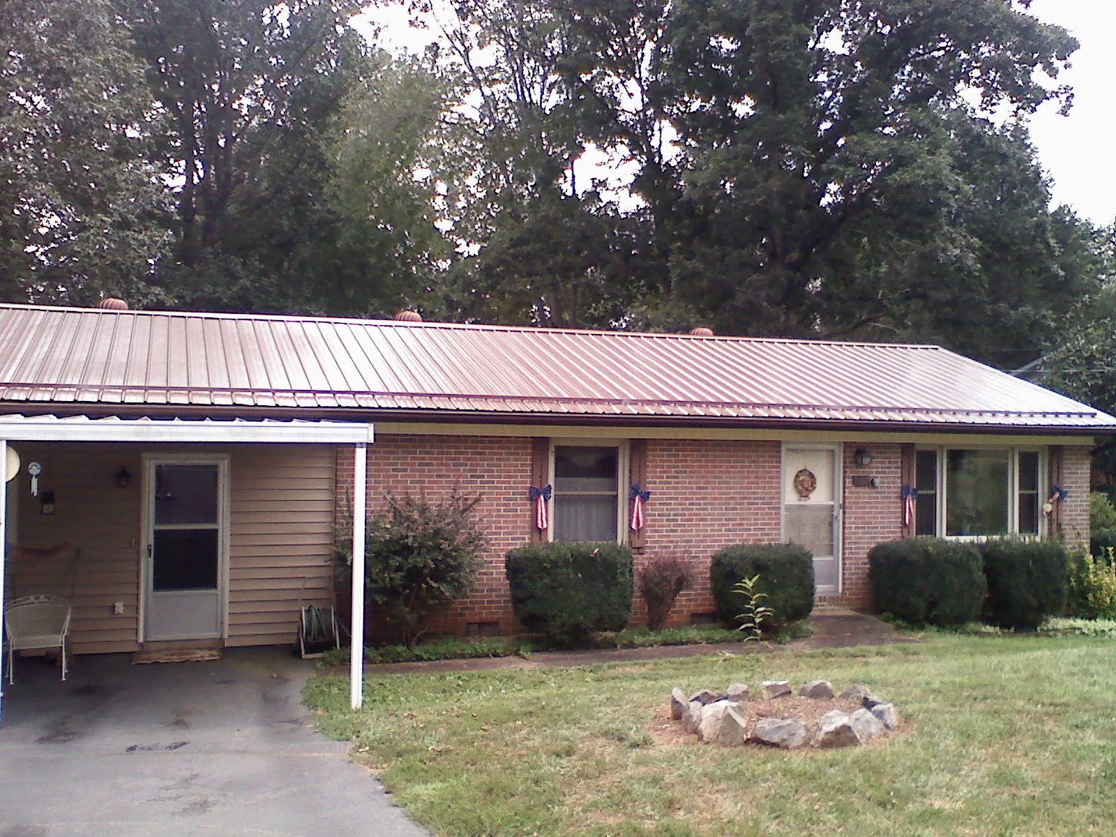 Bronze metal roof and carport on a brick ranch home — Roof Repair work by our crew in King Of Prussia