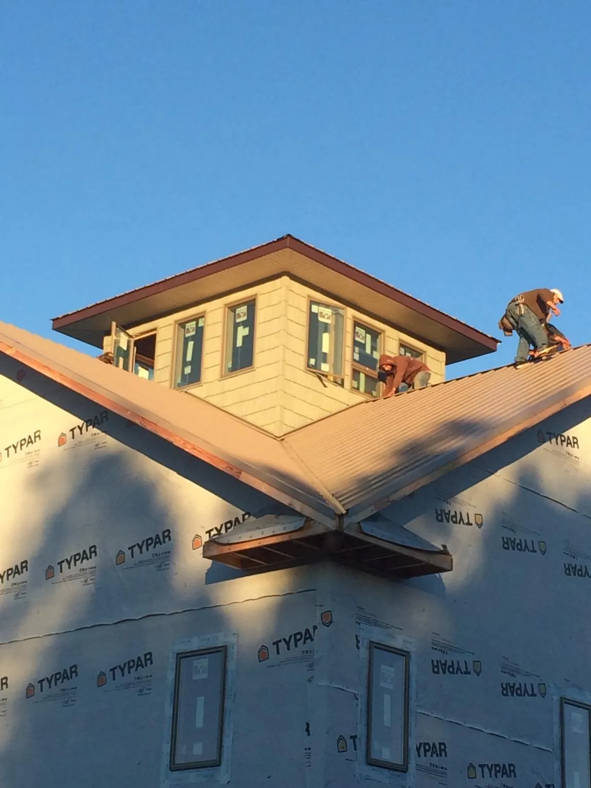 Roofers working around a rooftop cupola on a new metal roof at sunset — Roof Waterproofing in King Of Prussia by Roofing Brothers